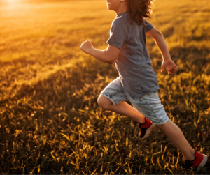 Child running in field in summer